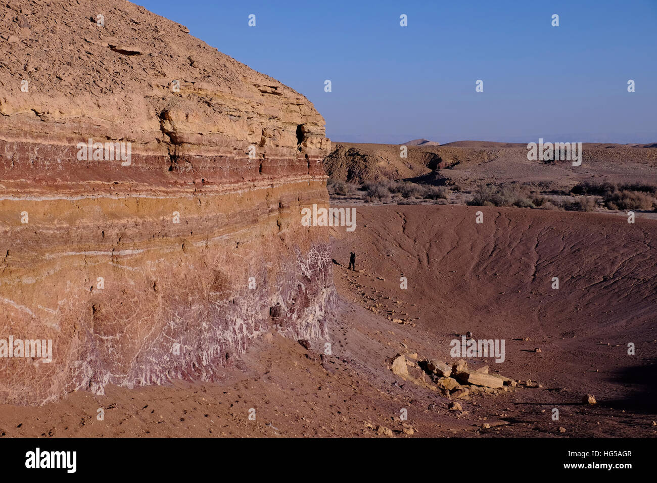Un dyke magmatique des couches horizontales des bandes de couleur dans une roche sédimentaire à Beerot Khan au milieu du grand cratère Makhtesh Ramon un relief géologique considéré comme unique pour le désert du Néguev, pas été créé par des météores, mais par le processus d'érosion dans le sud d'Israël Banque D'Images