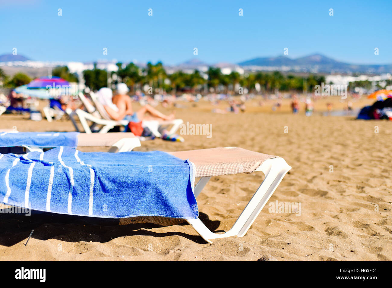 Les gens méconnaissables au soleil Playa de Matagorda plage de Puerto del Carmen, Lanzarote, dans les îles Canaries, Espagne Banque D'Images