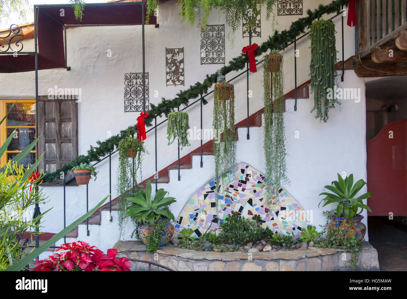 Plaza centre avec plantes suspendues et des pots dans un escalier contre un mur d'adobe dans Old Town, San Diego, Californie Banque D'Images