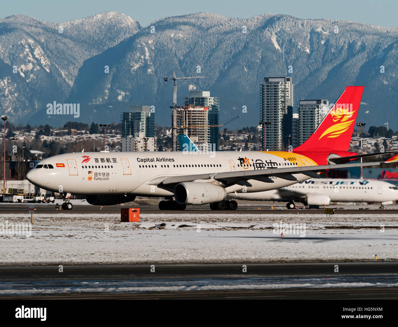 Beijing Capital Airlines Airbus A330-200 (B-8550) prend un avion décollant de l'Aéroport International de Vancouver sur la neige d'hiver Banque D'Images