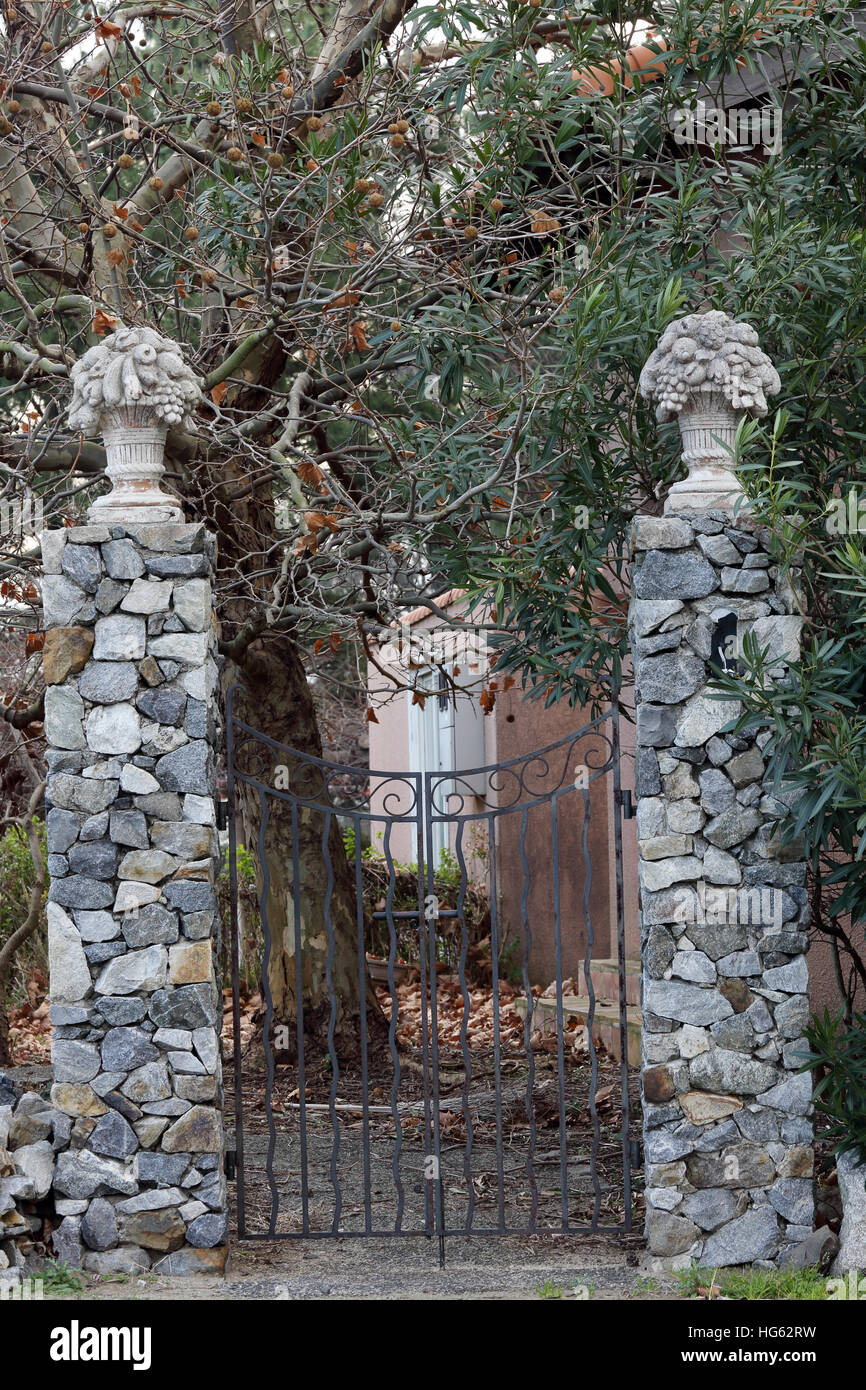 Vieille porte de fer entre deux piliers en brique de maçonnerie Banque D'Images