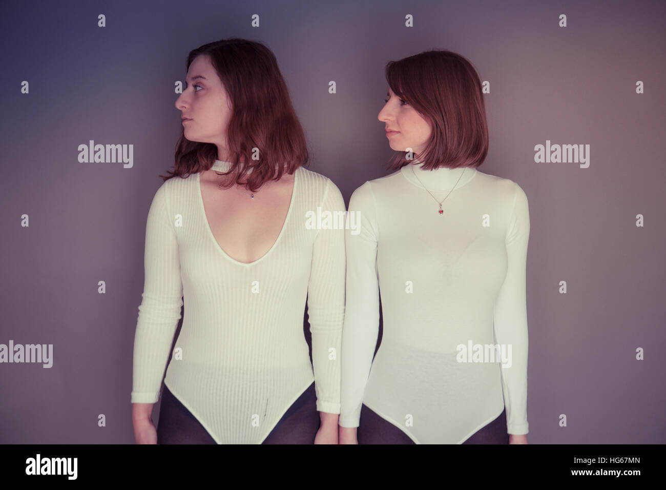 Doppelganger / Alter-ego photoshoot à thème : deux jeunes femmes les filles  portant des vêtements correspondant permanent s'est réuni l'écho  correspondant à chaque mise en miroir d'autres posent et d'expression  physique -