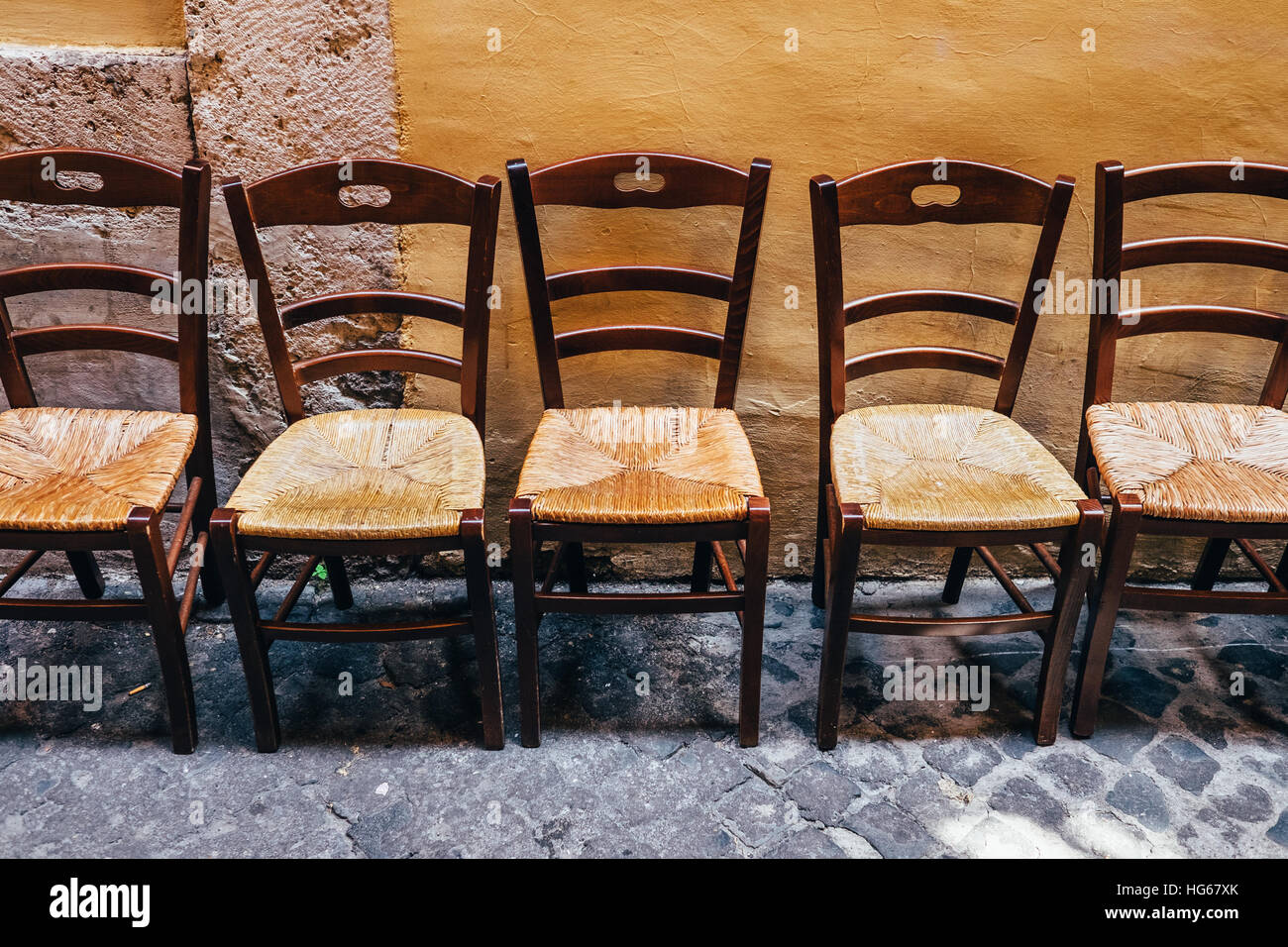 Une ligne de chaises dépareillées légèrement à l'extérieur d'un restaurant à Rome, Italie Banque D'Images