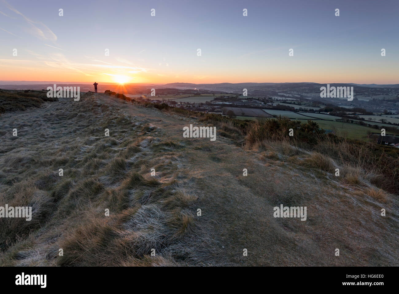 Une colline walker de prendre une photo sur Moel-y-Gaer fort de colline près du village de Rhosesmor, Flintshire pendant s givre hiver matin, Pays de Galles, Royaume-Uni Banque D'Images