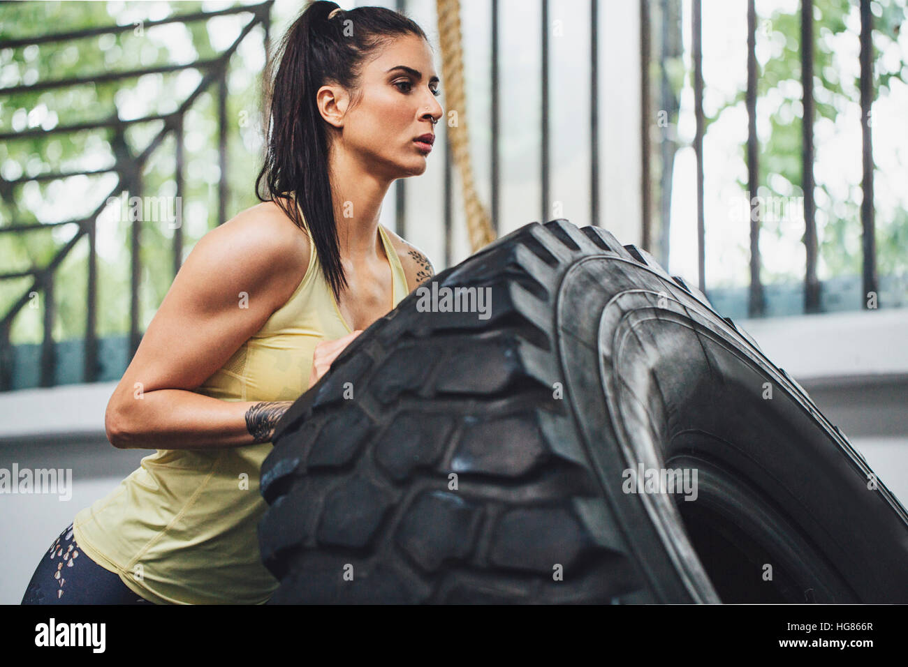 L'exercice de l'athlète avec le pneu du tracteur en salle de sport Banque D'Images