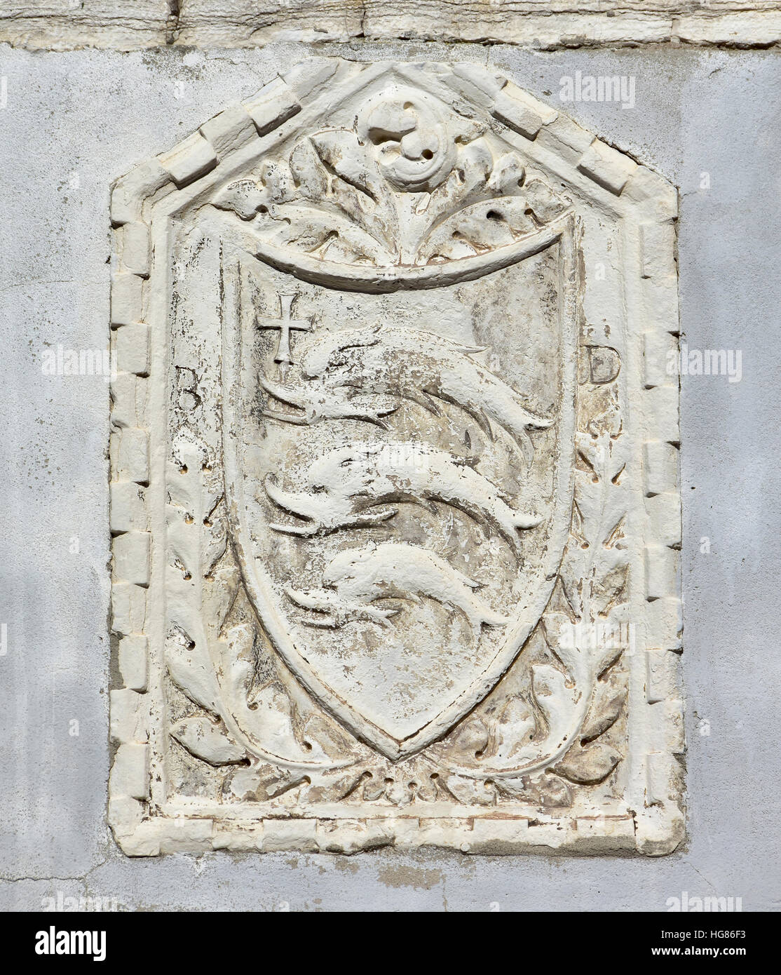 Ancien noble emblème avec trois dauphins (ou de poisson) avec une croix sur un mur à Venise Banque D'Images