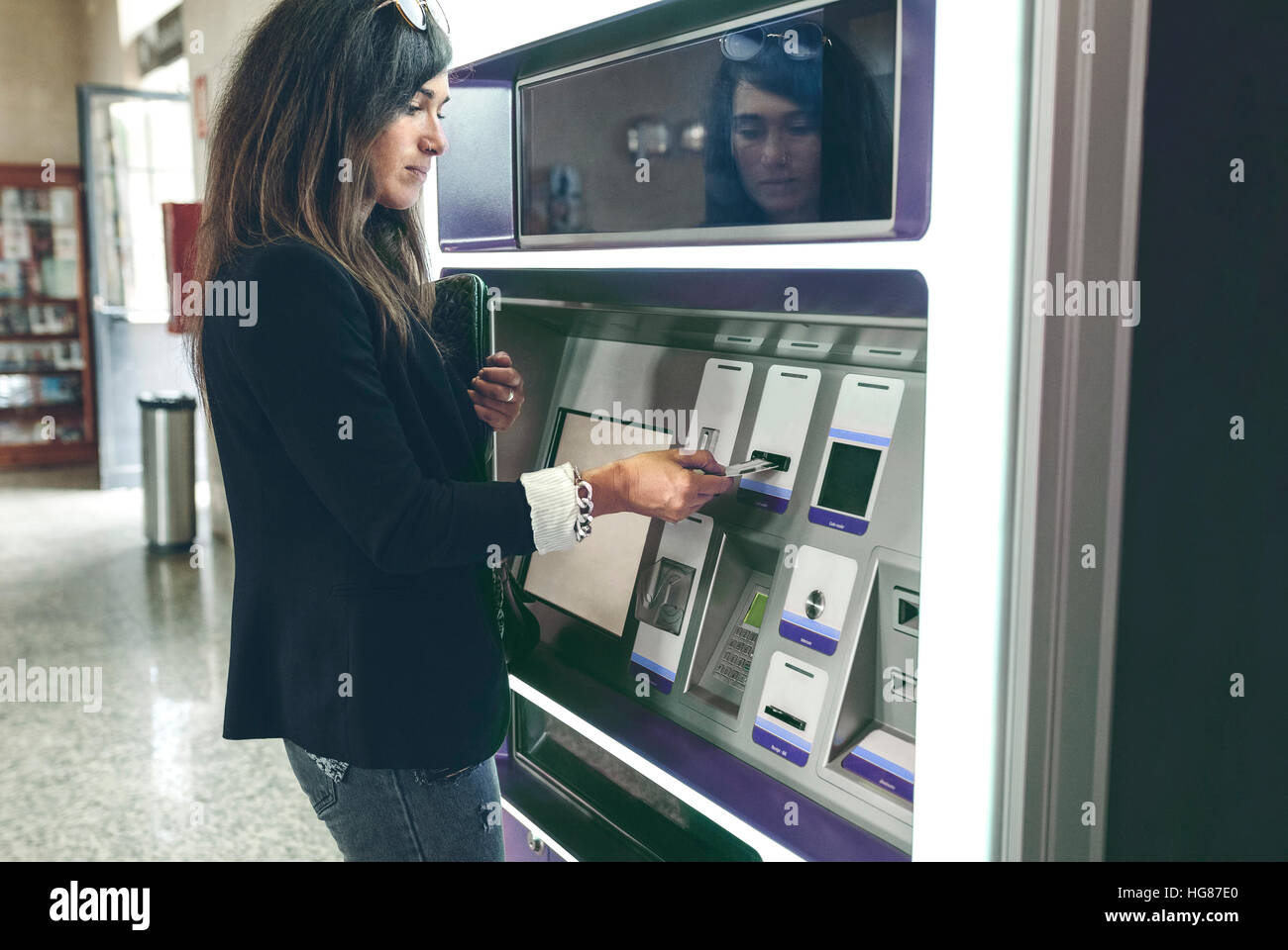 Femme dans l'insertion d'une carte ATM machine Banque D'Images