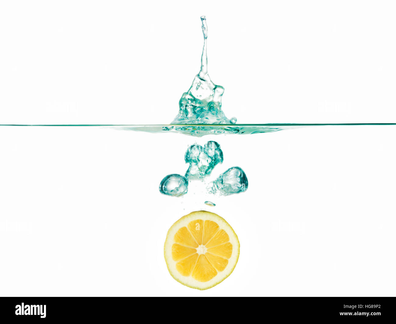 Tranche de citron dans l'eau contre fond blanc Banque D'Images