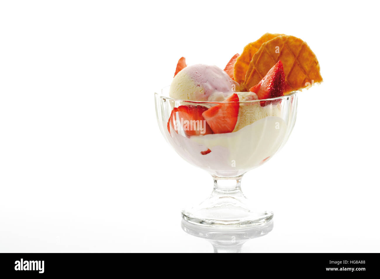 Glace vanille, fraises et crème fouettée dans un verre parfait Banque D'Images