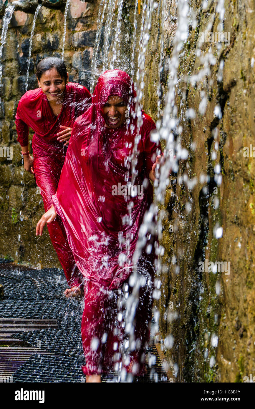 Deux femmes pèlerins fonctionnant par les 108 puits de sainte, la douche pour purifier le corps et l'âme, Muktinath, District de Mustang Banque D'Images