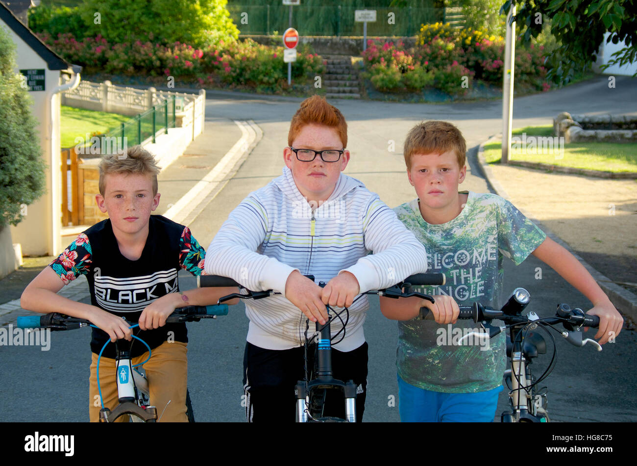 Gang de jeunes garçons sur des vélos sur une rue de banlieue Banque D'Images