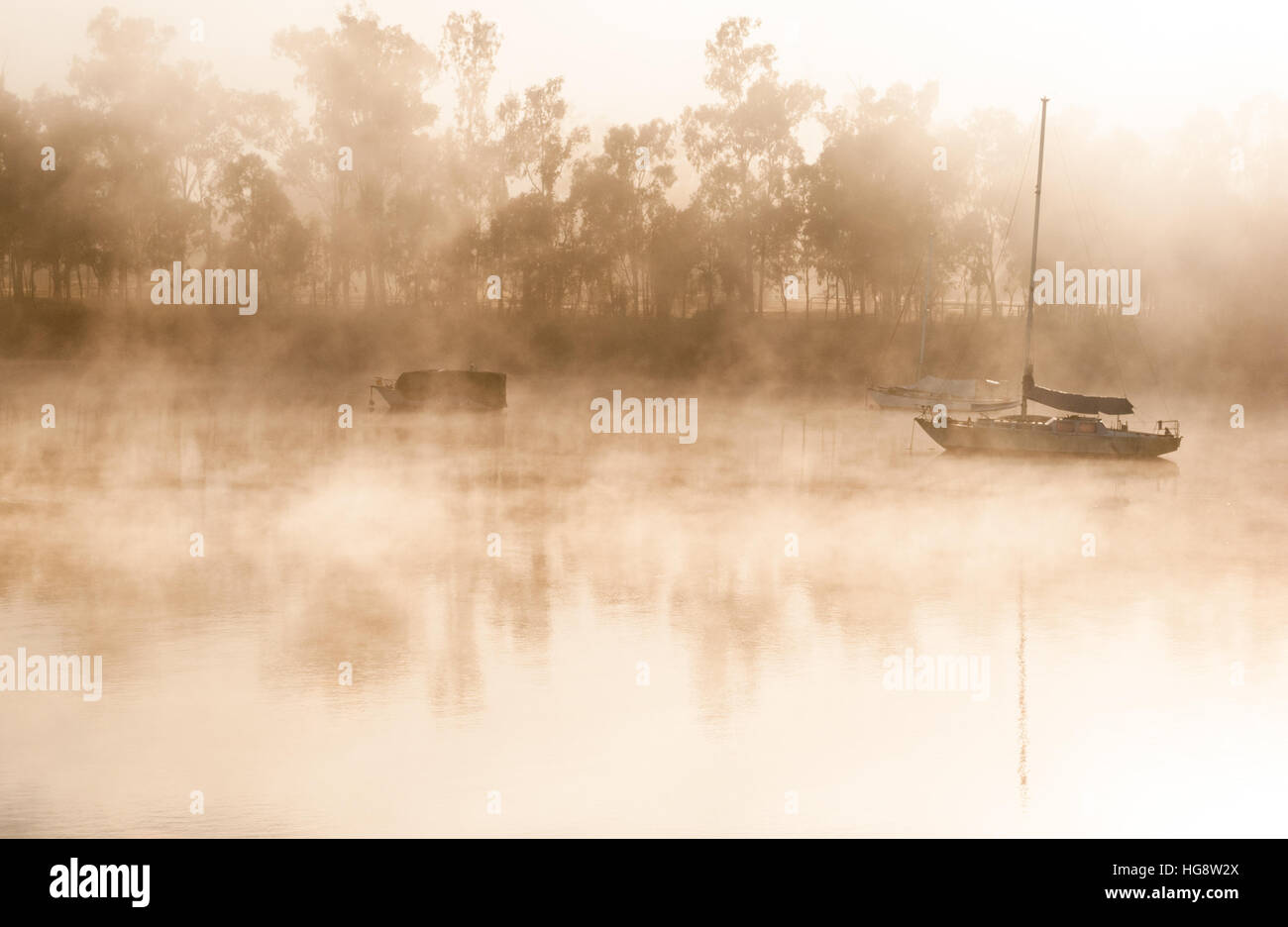 Matin brumeux sur une rivière avec des bateaux Banque D'Images