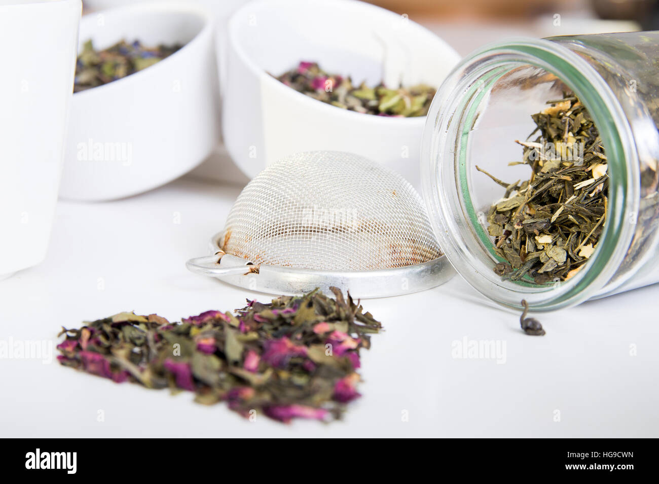 Le thé vert en pot et différentes sortes d'herbes sur la table en bois Banque D'Images