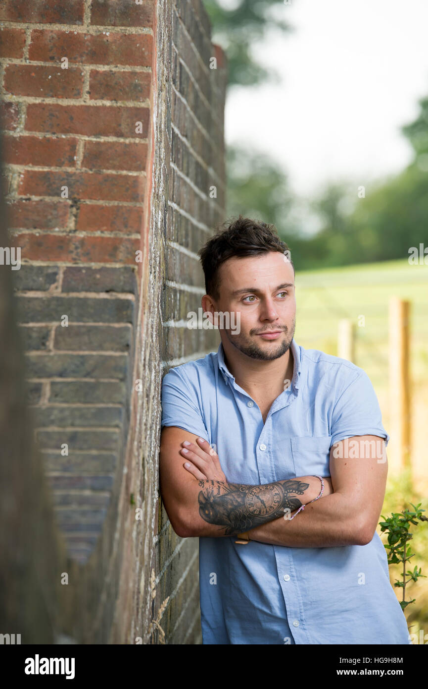 Chanteur, auteur-compositeur Jamie Mathias pose avec sa guitare pour un tournage à l'Ouse valley viaduc, Sussex, UK. Banque D'Images