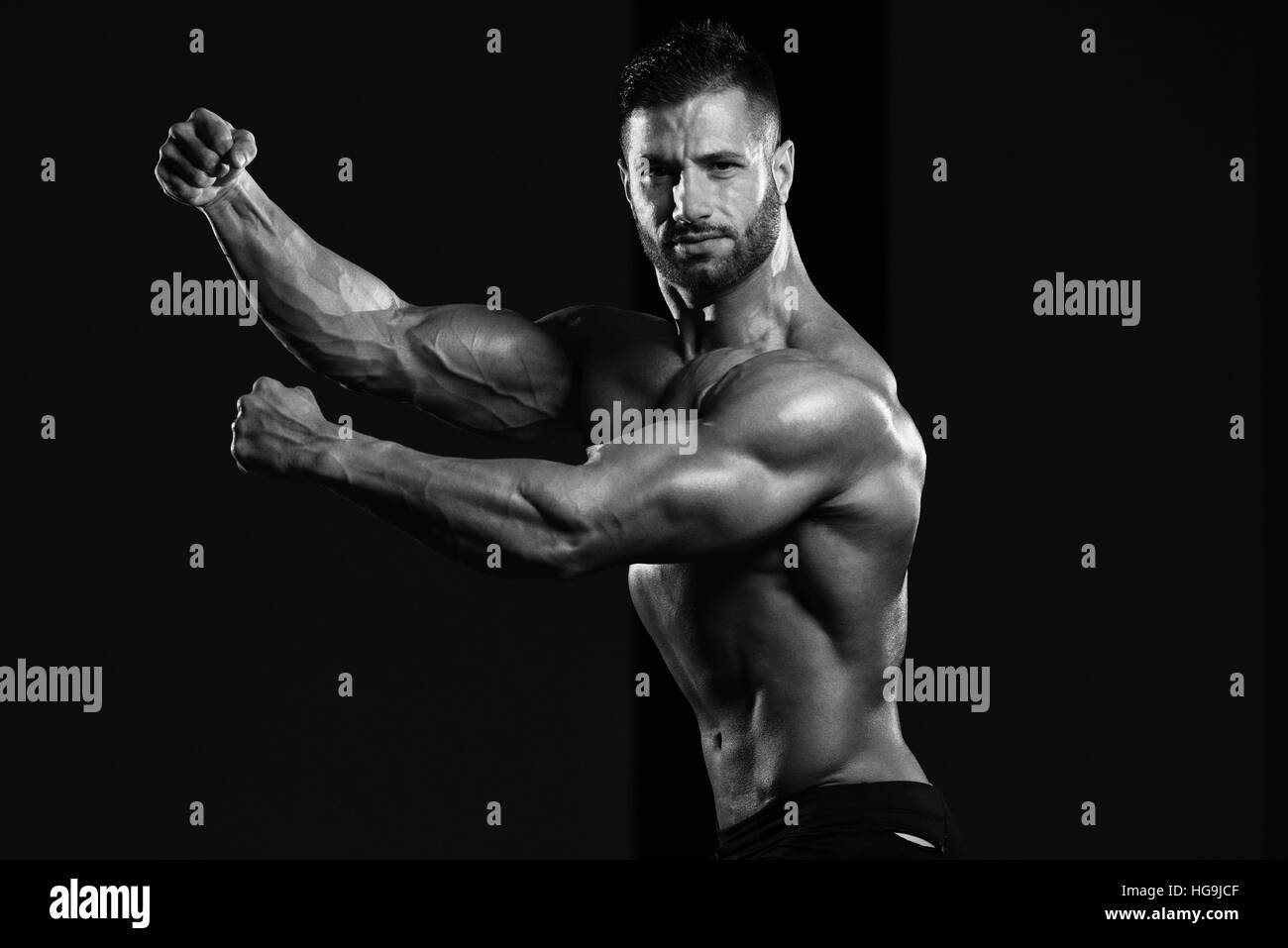 Homme en bonne santé Soyons forts dans la salle de sport et Flexing Muscles musculaire - Fitness Model Posing Bodybuilder athlétiques exercices après Banque D'Images