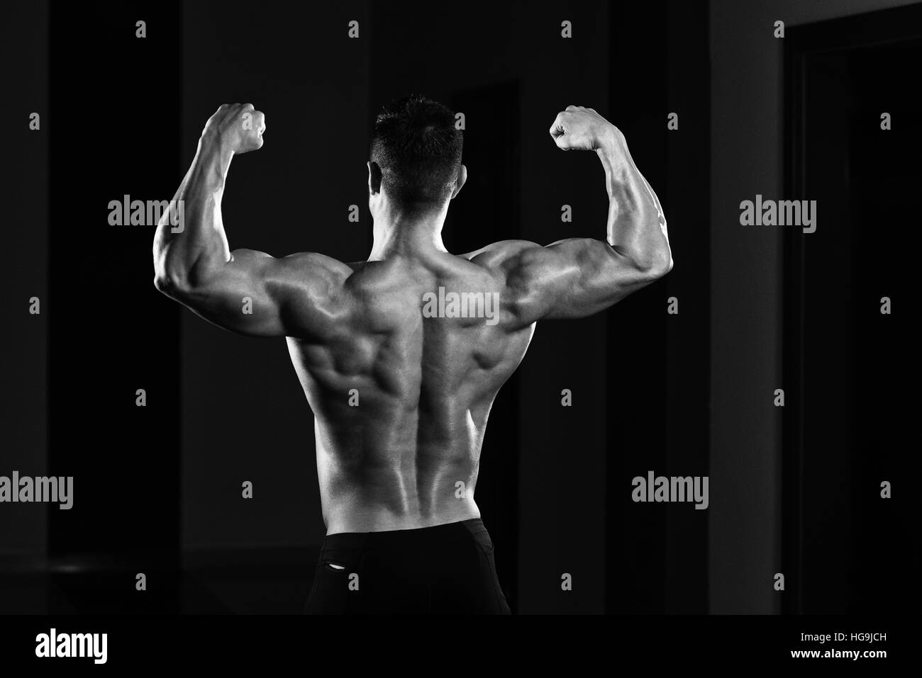Bel homme Soyons forts dans la salle de sport et Flexing Muscles musculaire - Fitness Model Posing Bodybuilder athlétiques exercices après Banque D'Images