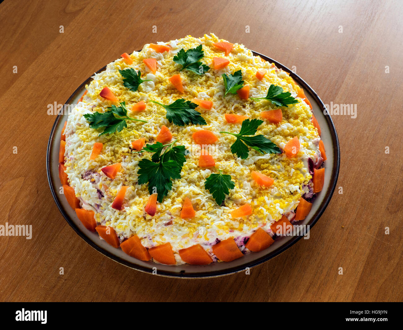 Le hareng sous un manteau de fourrure, une salade faite de filet de hareng salé, des pommes de terre, betteraves, carottes, oignons frais et la mayonnaise sur une plaque Banque D'Images