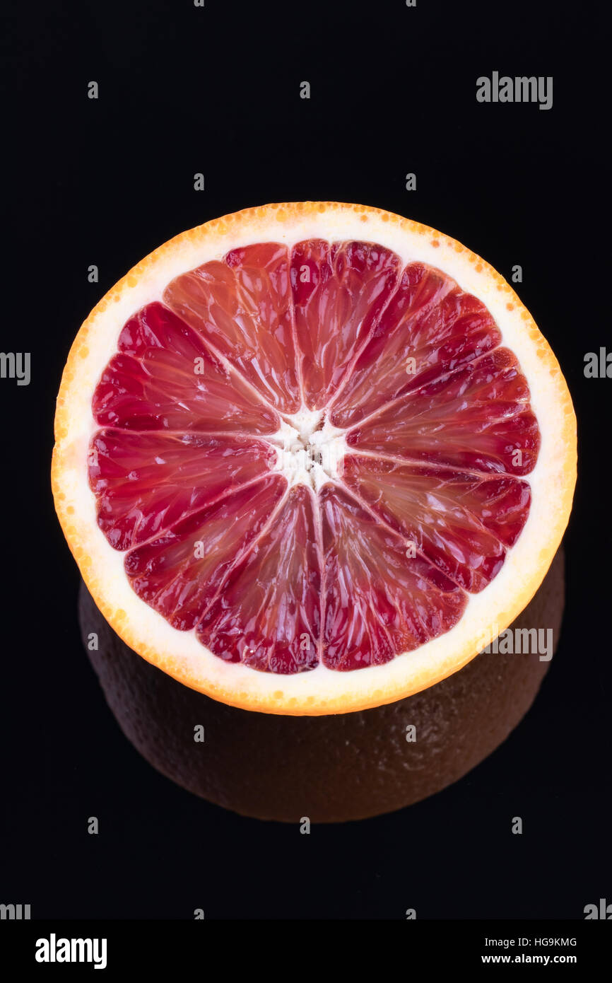 Seule la moitié d'une orange sanguine isolated on black Banque D'Images