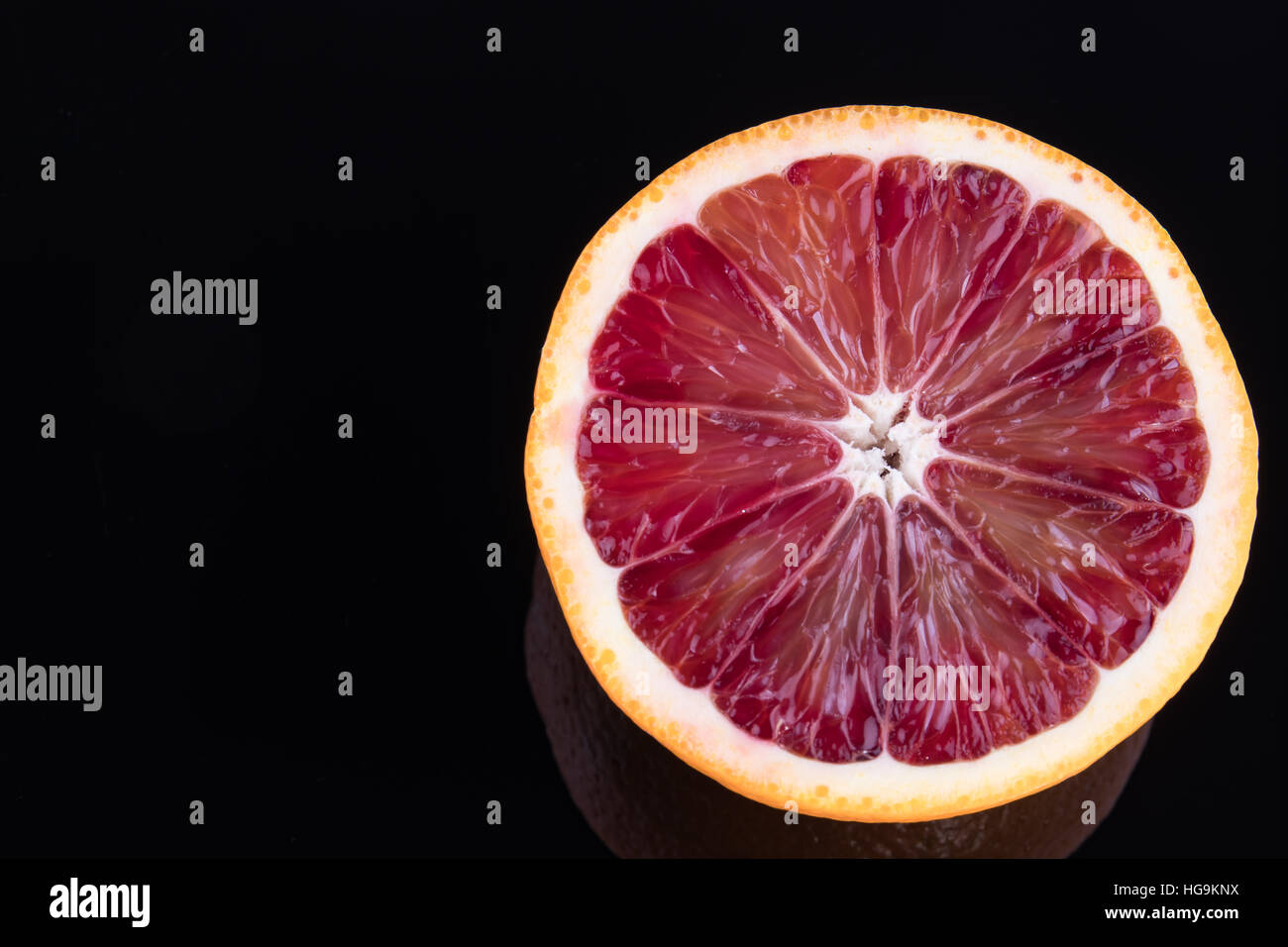 Seule la moitié d'une orange sanguine isolated on black Banque D'Images