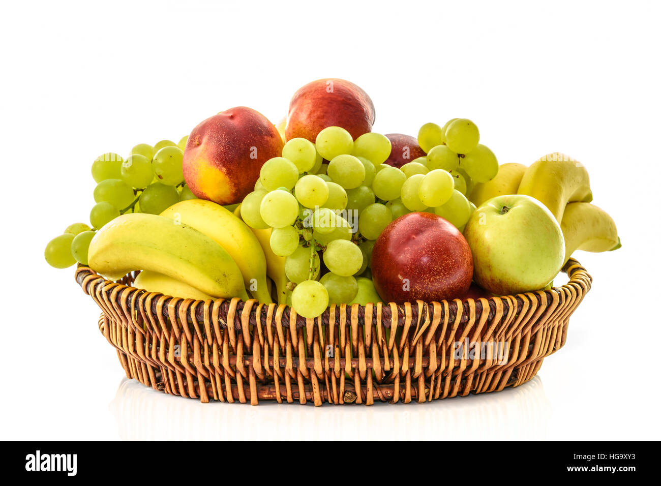 Panier en osier avec des fruits : banane, raisin, pêche, pomme Banque D'Images