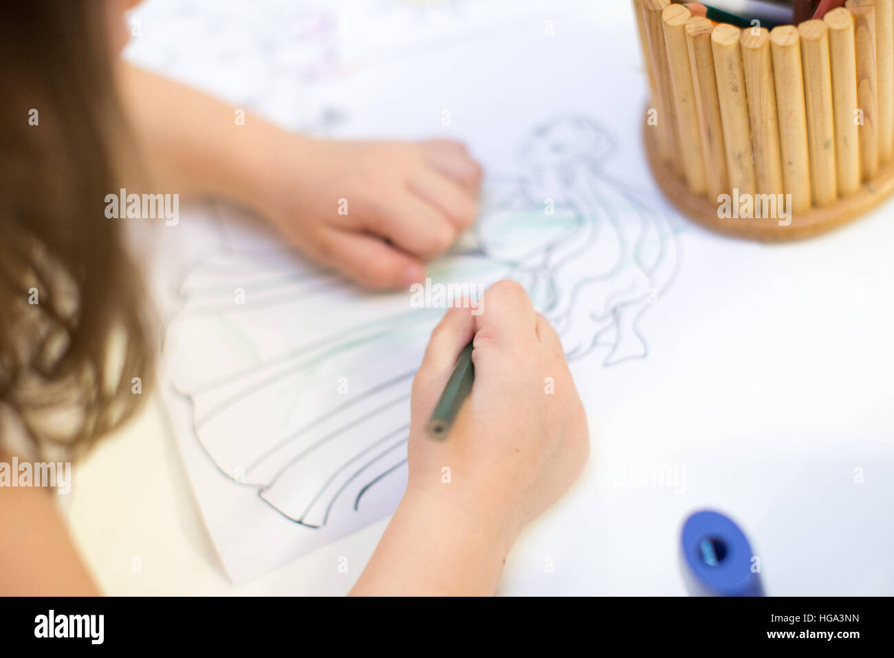 Jeune fille au livre de coloriage pour enfants attire l'anniversaire. Banque D'Images