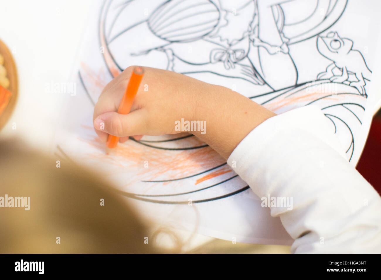 Jeune fille au livre de coloriage pour enfants attire l'anniversaire. Banque D'Images