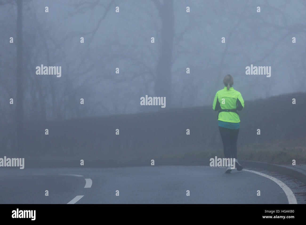 Une femme portant des jogger Hi Viz en faisant du jogging le long de la B4343 en tant que l'épais brouillard entrave la visibilité de ce matin. © Ian Jones/Alamy Live News Banque D'Images