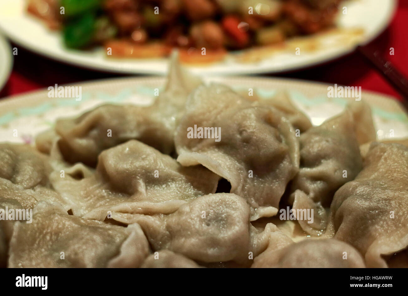 Chinois cuits boulettes en plaque sur table avec Gong Bao plat de poulet. Raviolis chinois sont traditionnellement servi pour le Nouvel An chinois, ou comme le Banque D'Images