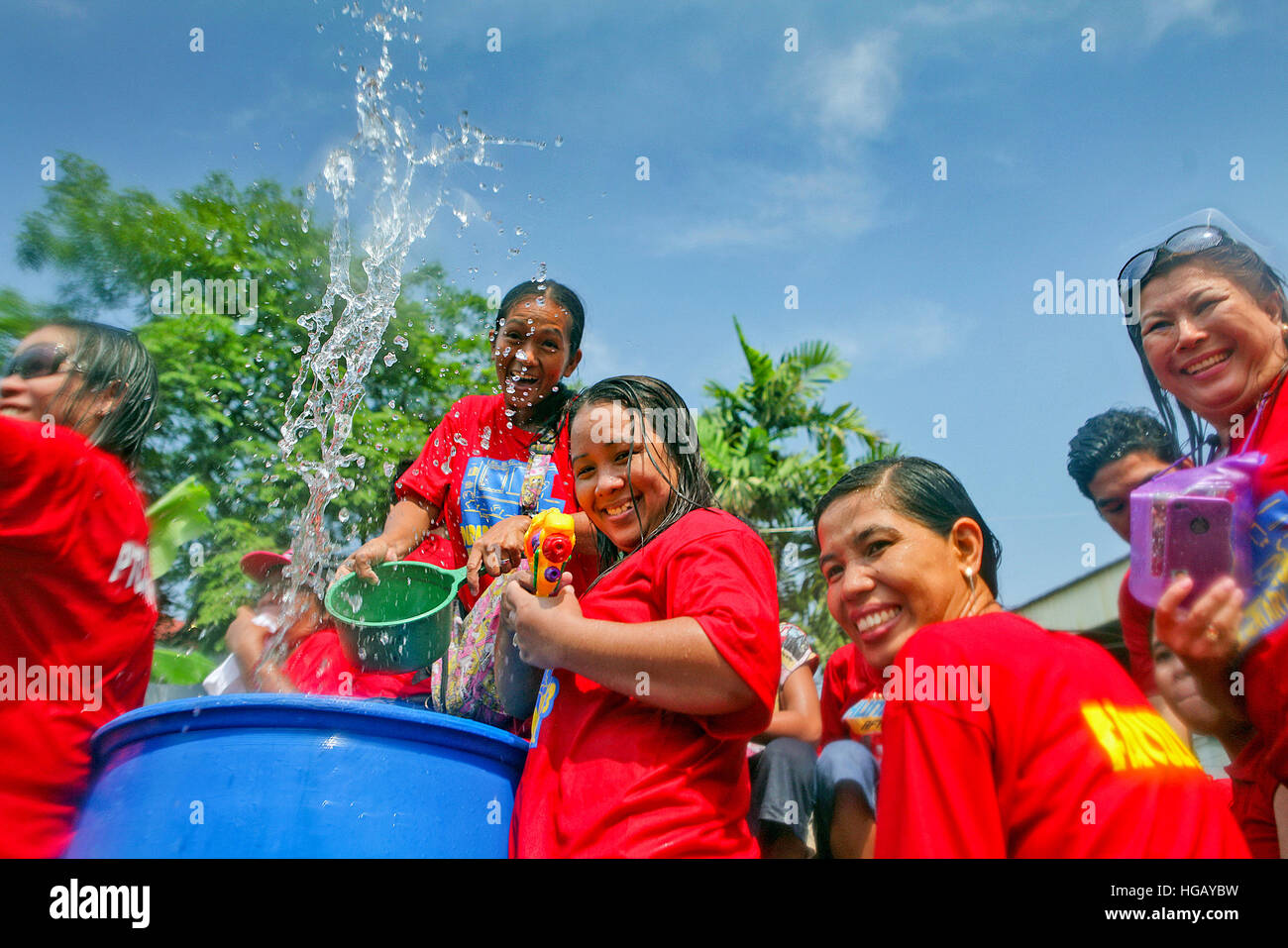 Les femmes jettent de l'eau sur les passants comme leur passe par le flotteur au cochon braisé Festival à Balayan, Batangas, Philippines. Banque D'Images