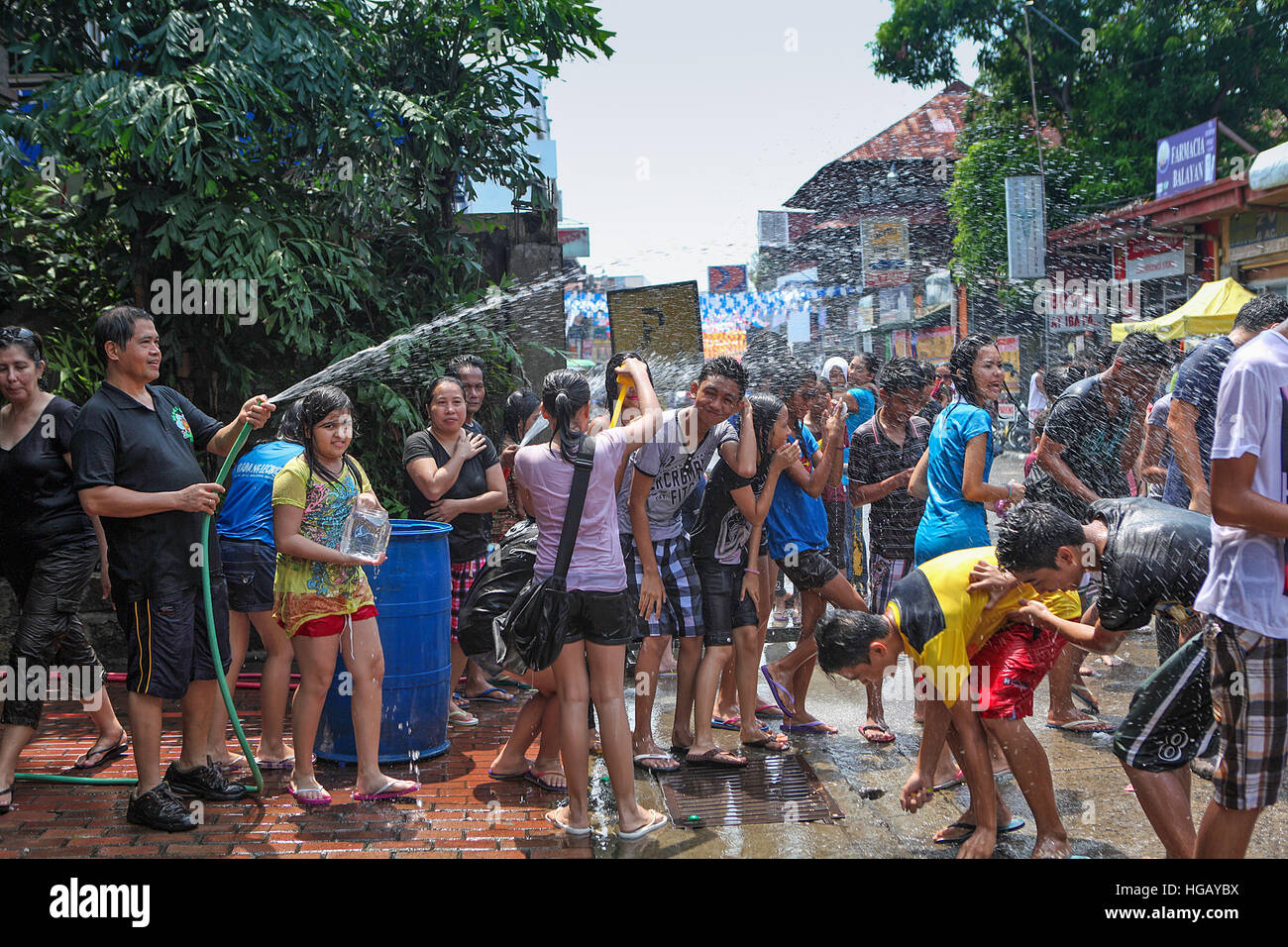 Squirt philippins de l'eau sur les personnes se trouvant à la fête cochon braisé à Balayan, Luzon, Philippines. Banque D'Images