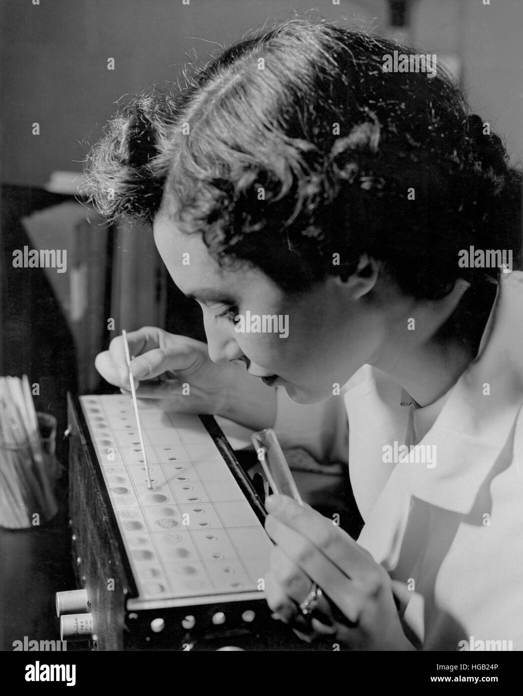 Technicien de laboratoire d'un échantillon de sang afficher la saisie, 1957. Banque D'Images