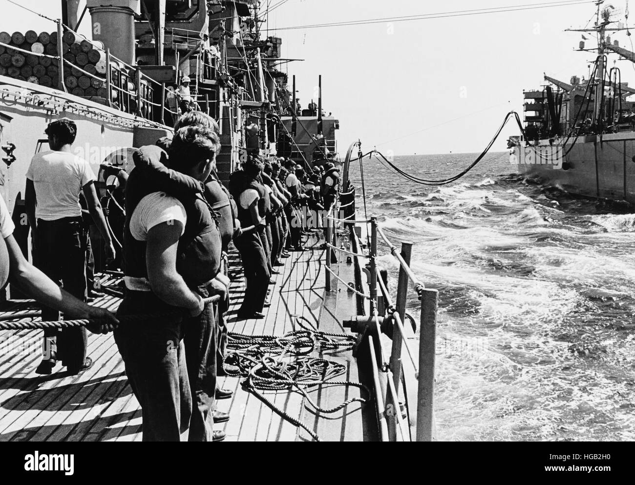 Les gestionnaires de la ligne à bord du USS Boston apporter à travers un tuyau de carburant de l'USS Camden, guerre du Vietnam, 1968. Banque D'Images