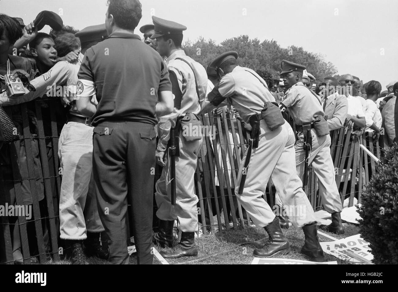 Une foule d'Américains africains derrière une clôture avec la police de l'autre côté, 1963. Banque D'Images