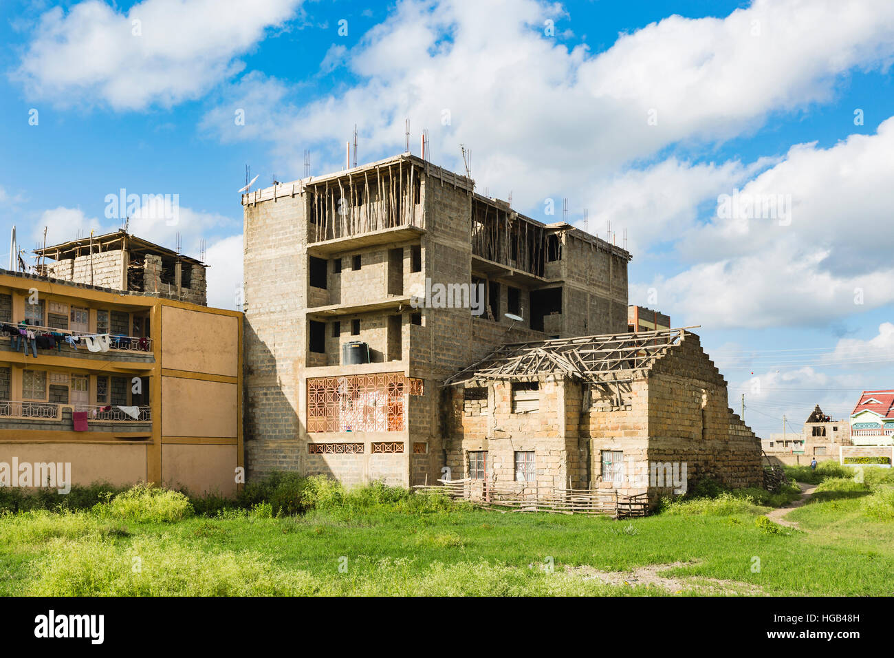 Une ruine à côté d'un bâtiment en construction, une vue typique dans le village de Tassia dans l'Est de Nairobi, Kenya. Banque D'Images