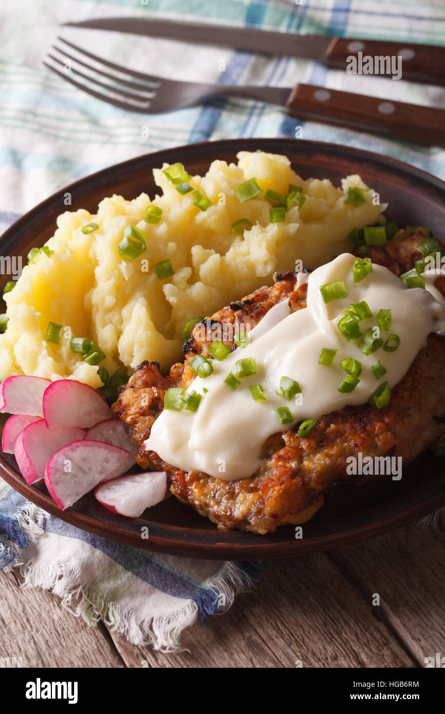 Pays fried steak avec garniture de pommes de terre sur une plaque verticale close-up Banque D'Images