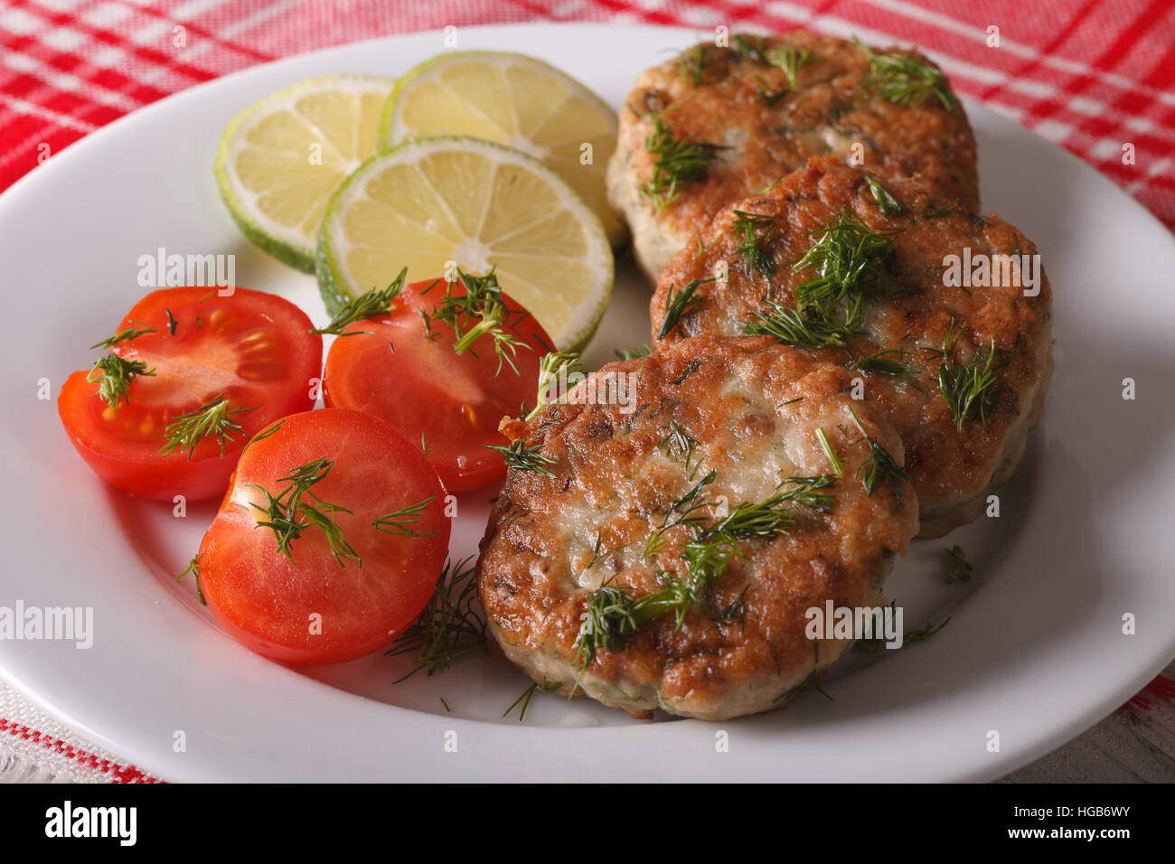 Les escalopes de filets de poisson blanc avec des fines herbes gros plan sur une assiette blanche horizontale. Banque D'Images