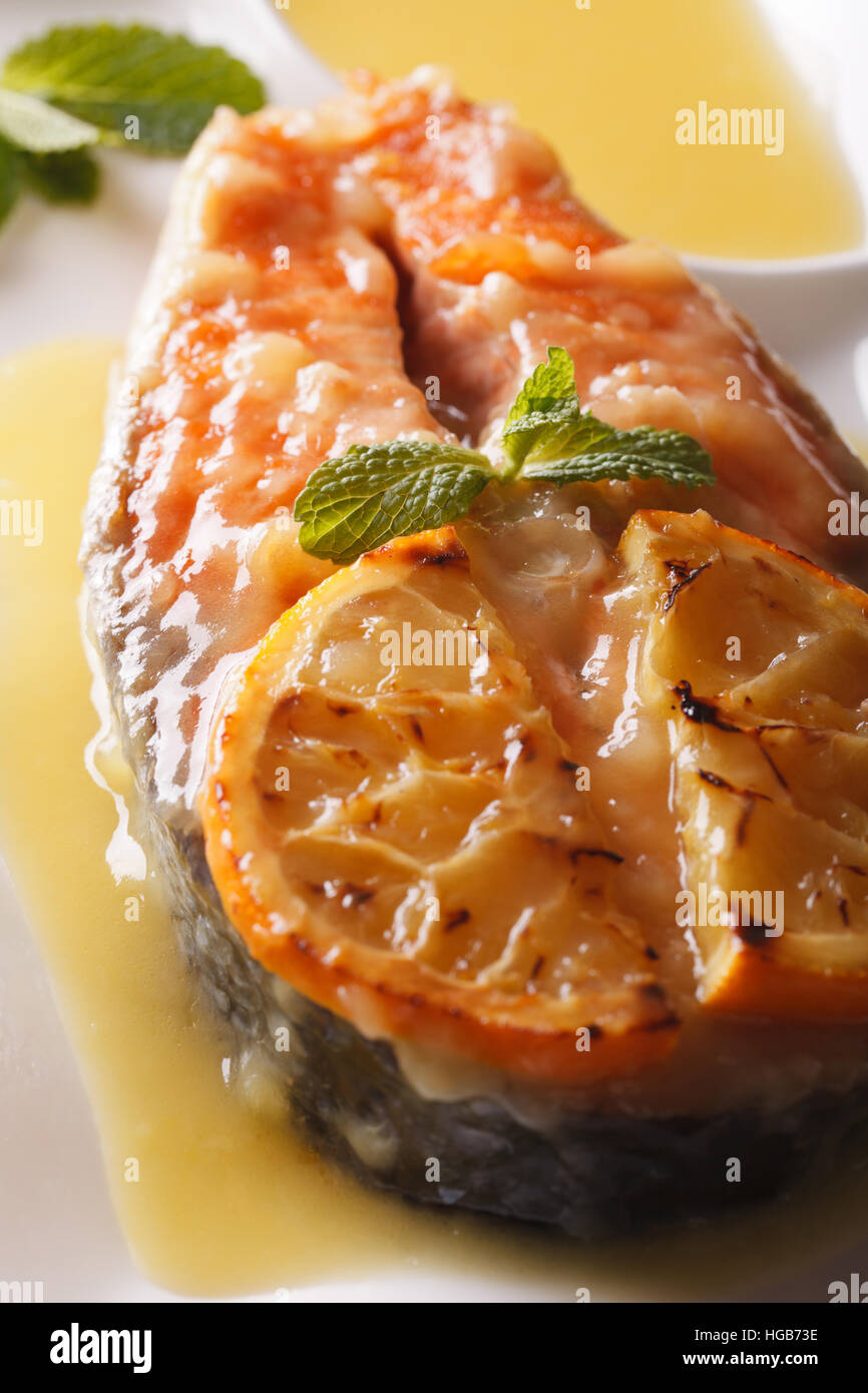 Pavé de saumon au four à l'orange sur une plaque verticale macro. Banque D'Images