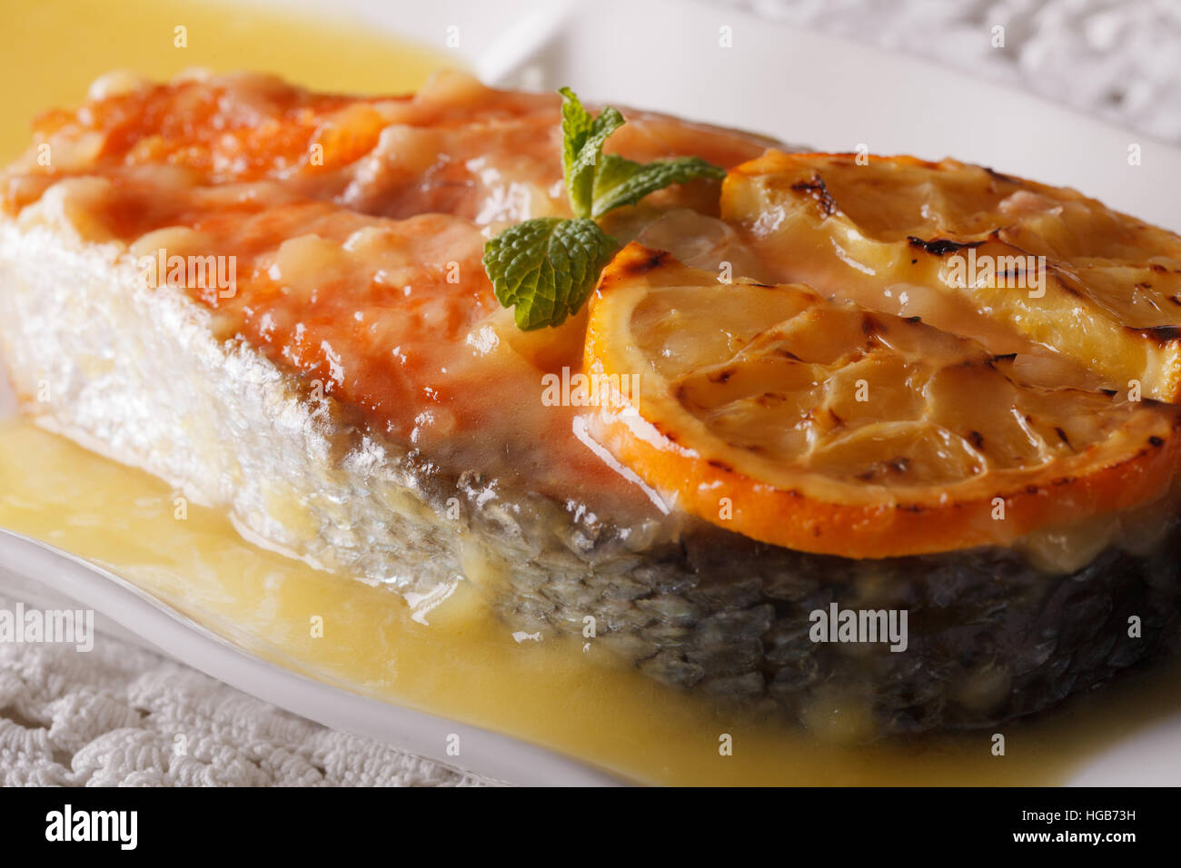 Saumon au four avec sauce à l'orange sur une plaque horizontale de macro. Banque D'Images