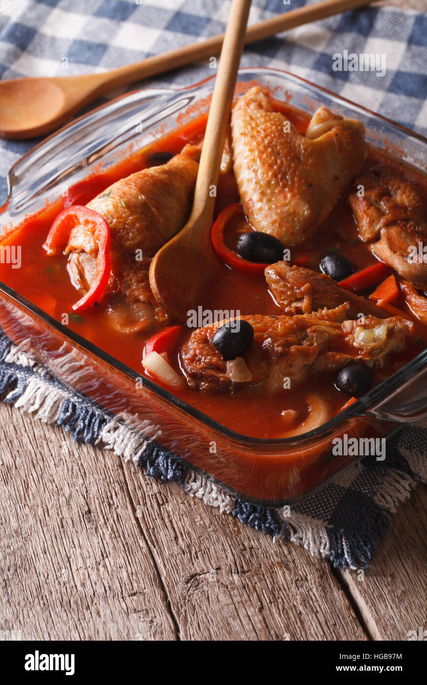 Délicieux ragoût de poulet en sauce tomate aux olives et le poivre dans un bol en verre verticale. Banque D'Images