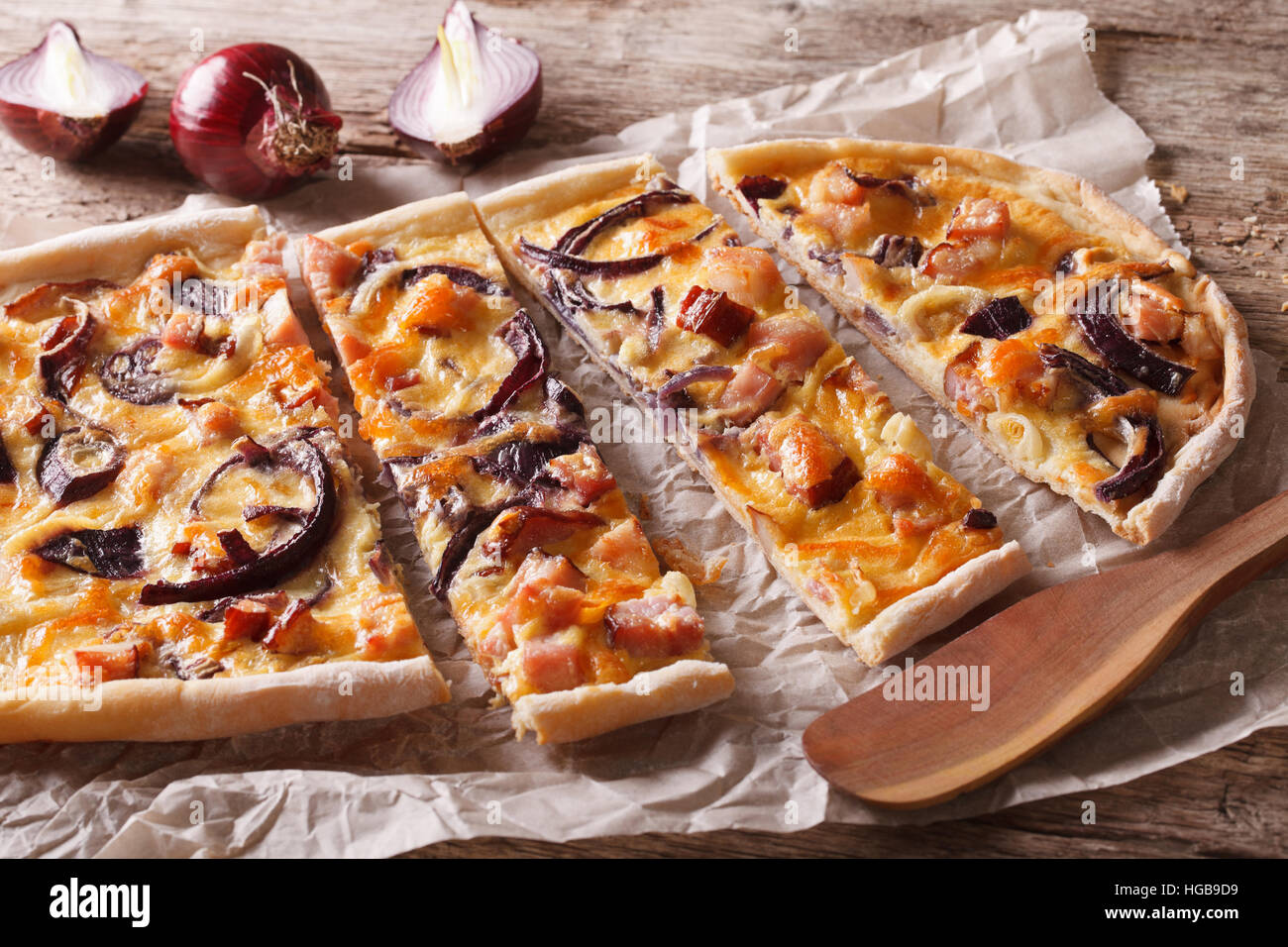 Tranches de bacon et pie flammkuchen avec oignon rouge sur le papier. Gros plan horizontal Banque D'Images