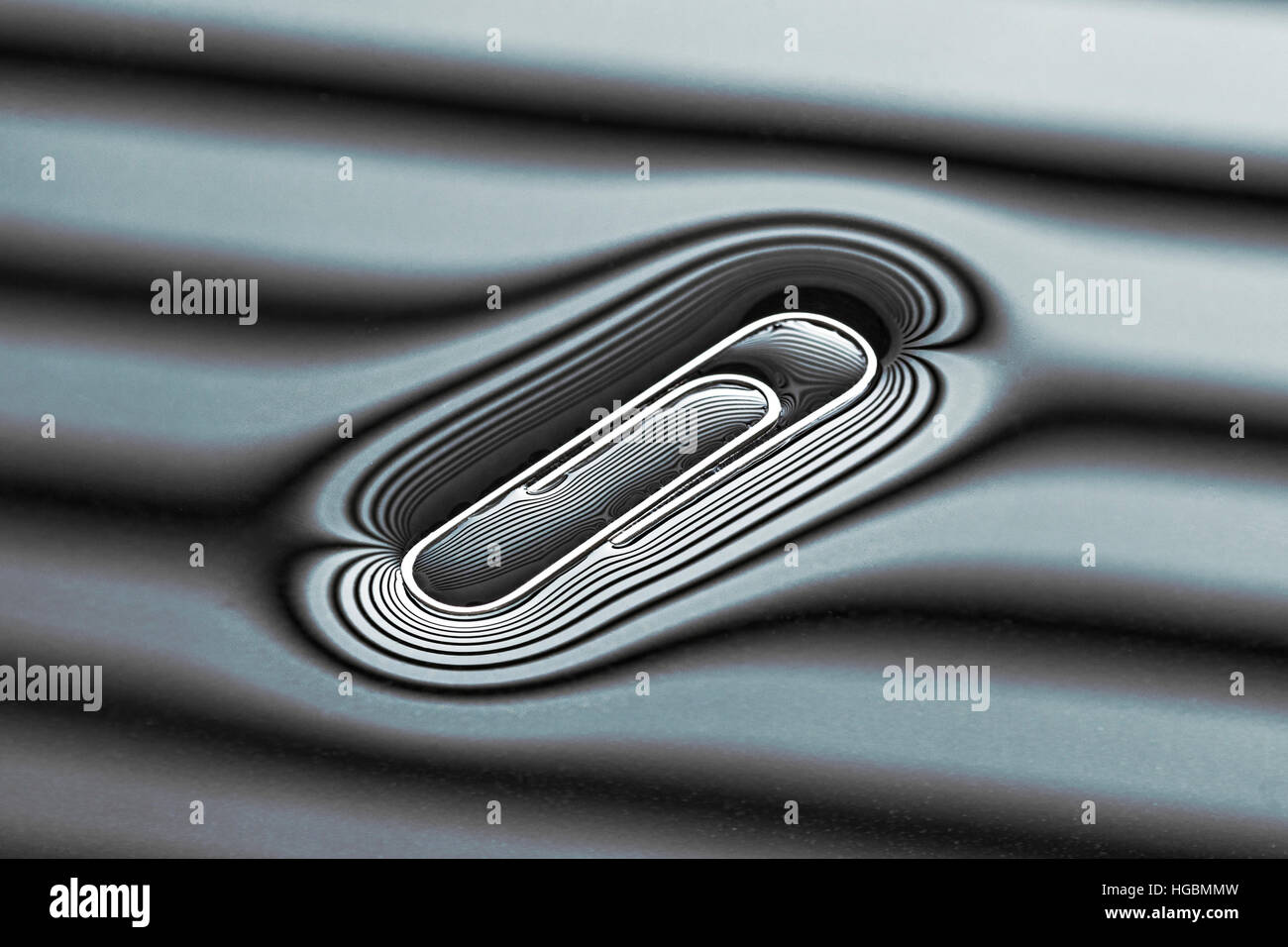 Trombone flottant. Trombone flottant sur l'eau avec la permission de la tension superficielle. Forme de l'eau de surface pris dans le compte des lignes sur la surface. Banque D'Images