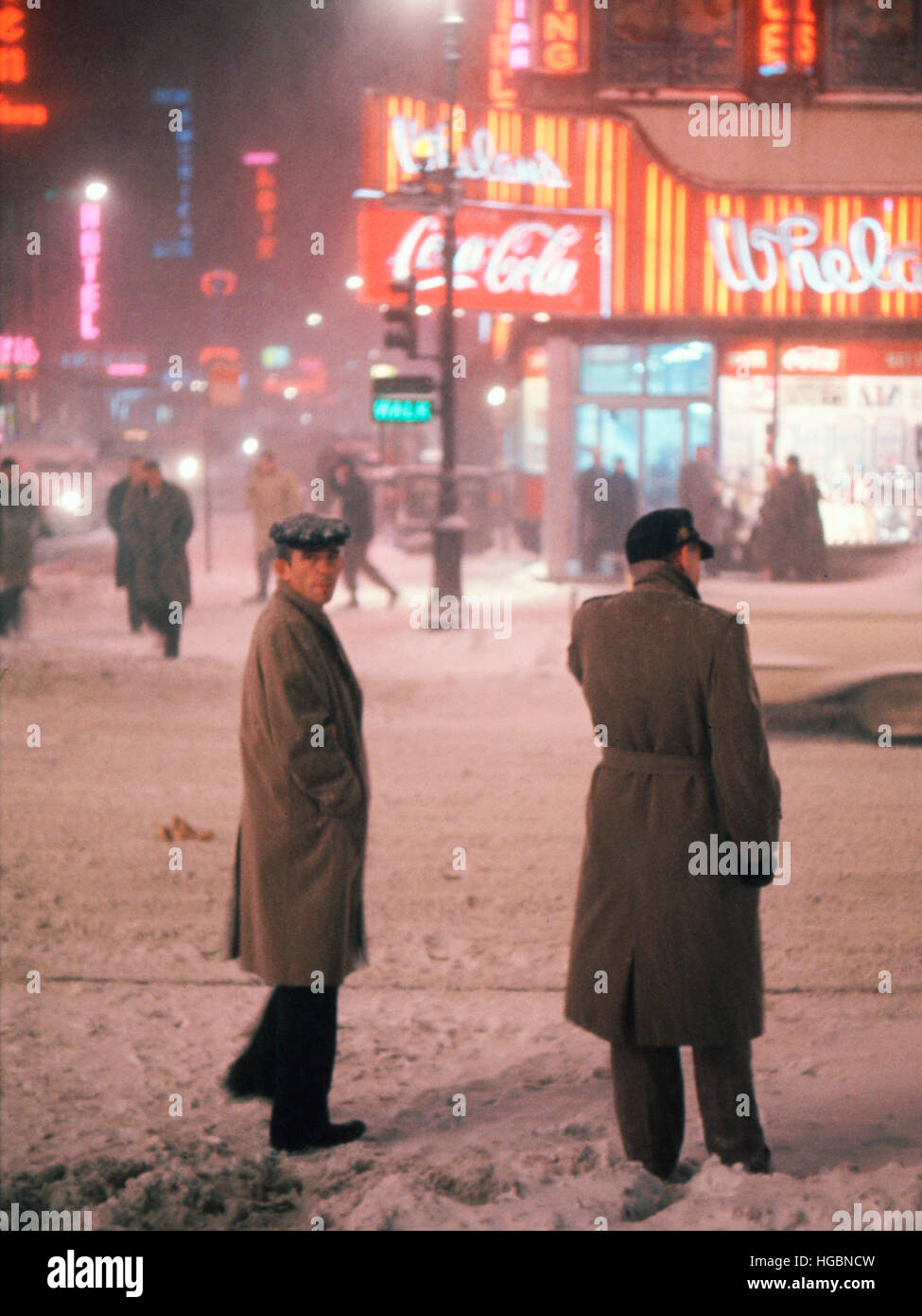 Probablement 1962, deux hommes naviguer dans les rues de Manhattan, pendant une tempête. Banque D'Images