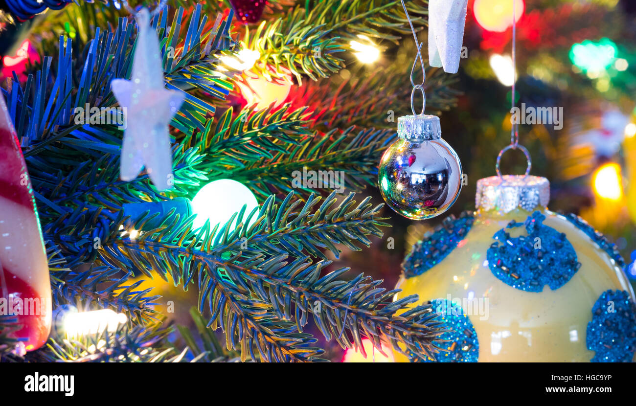 Décorations de Noël. Jaune, finition brillante orbe avec cercles bleus, les lueurs, entouré de lumières multicolores éclatantes,lumineux Banque D'Images