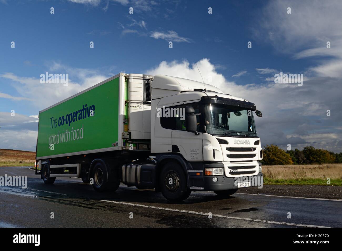 Remorquage camion Scania remorque réfrigérée alimentaire coopératif sur une route mouillée dans le Derbyshire avec moorland derrière et un ciel nuageux abo Banque D'Images