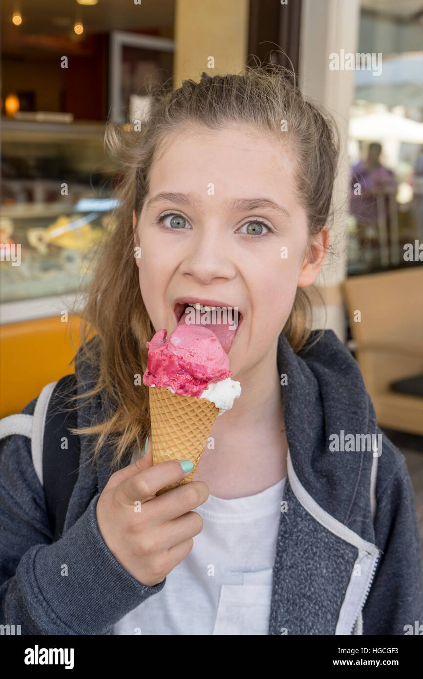 Une jeune fille est en train de manger une glace Banque D'Images