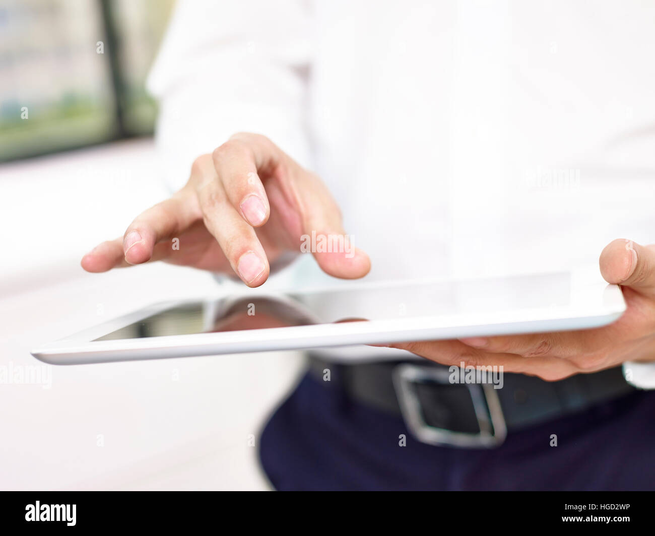 Gros plan des mains et des doigts d'un homme d'affaires à toucher l'écran d'un ordinateur tablette. Banque D'Images