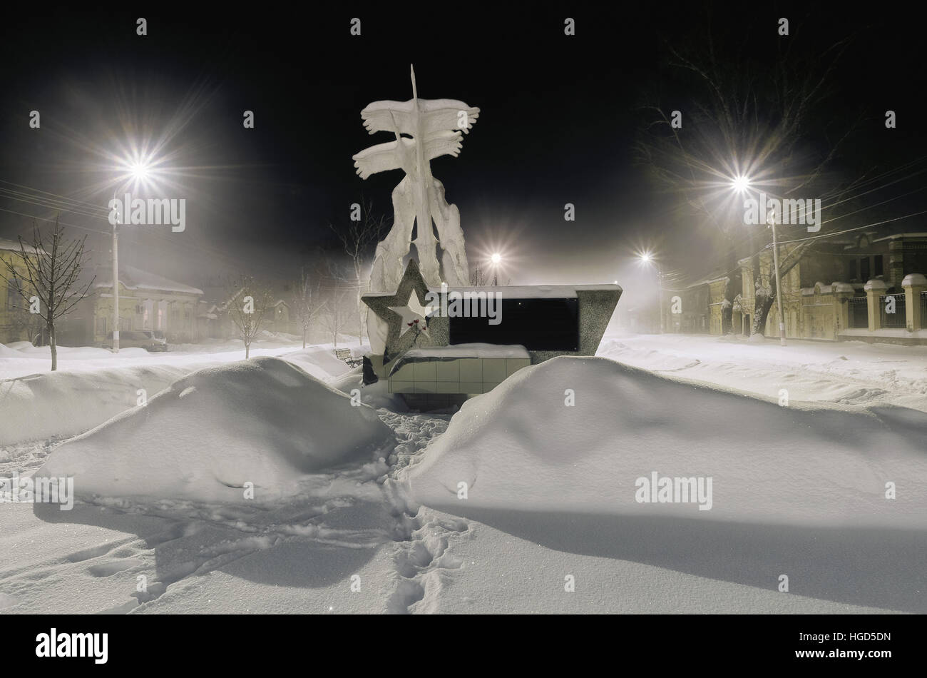 Dimitrovgrad Ulyanovsk region, Russie, le 6 janvier 2017. Dark city dans le brouillard et le monument aux soldats tués pendant la seconde guerre mondiale, le vol des oiseaux sont des grues. Banque D'Images