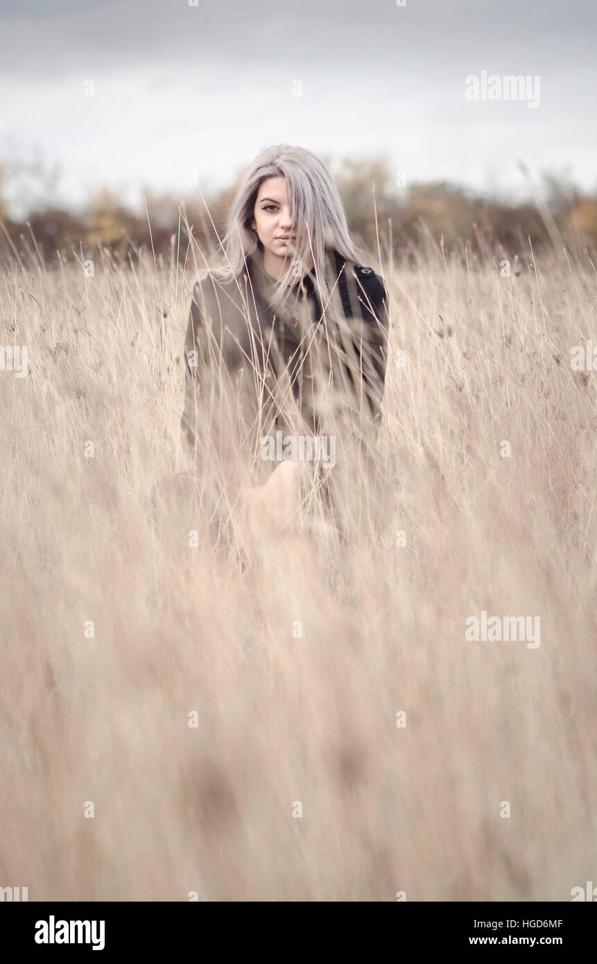 Jeune fille blonde dans le champ d'herbe d'hiver Banque D'Images