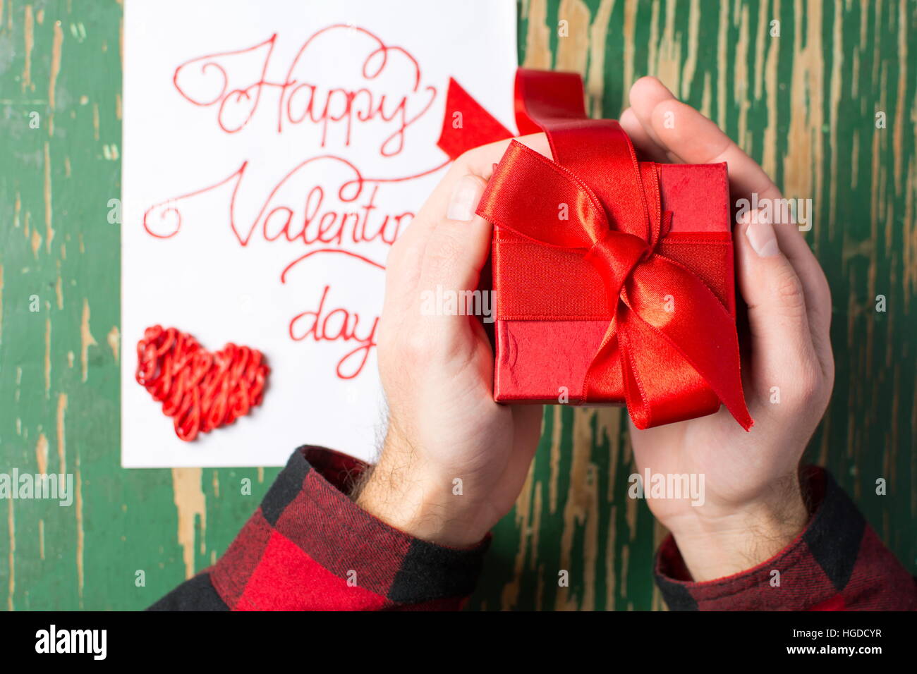 Male hands holding a red Valentines présent fort Banque D'Images