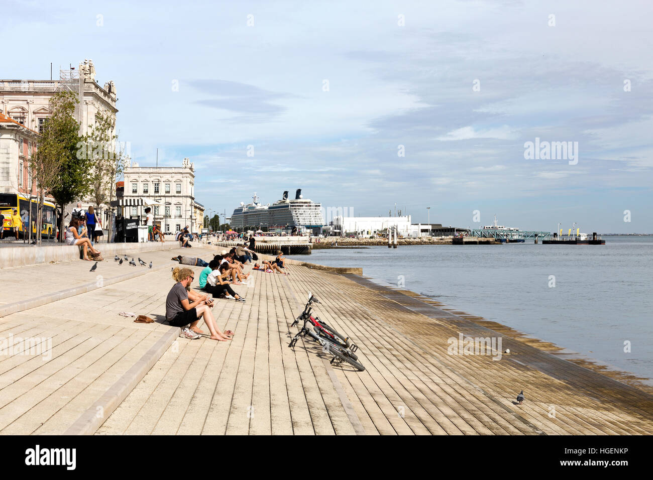 Les gens et le Tage beach et niverside Ribeira das Naus promenade Avenue, avec un bateau de croisière amarré à Lisbonne, Portugal Banque D'Images